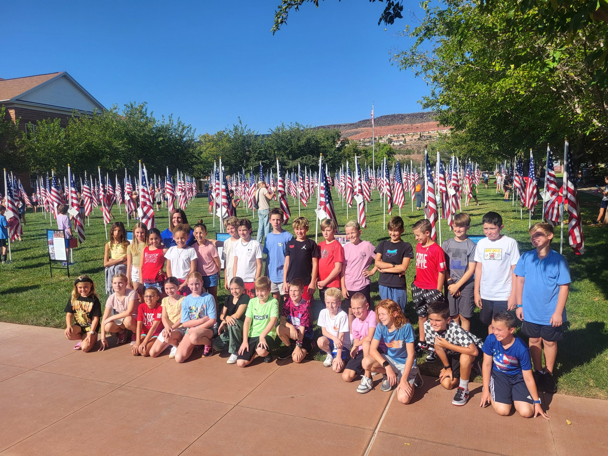 5th grade students standing in front of a field of American flags called Field of Flags
